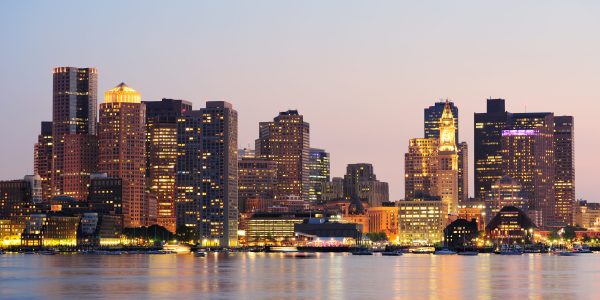 Boston downtown urban skyscrapers over water at dusk.